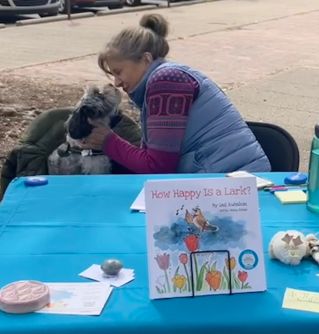 Dog and Gail nose to nose at her book table