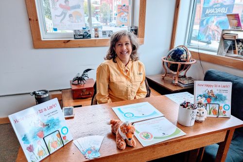 Gail Kuhnlein at her author table with her book, How Happy Is a Lark and props