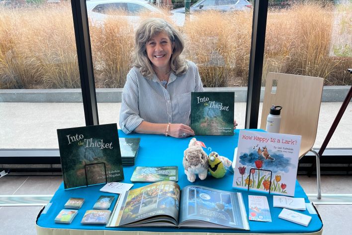 Gail sitting at her book table at Baldwin Public Library