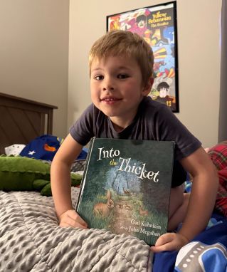 Little boy holding Into the Thicket