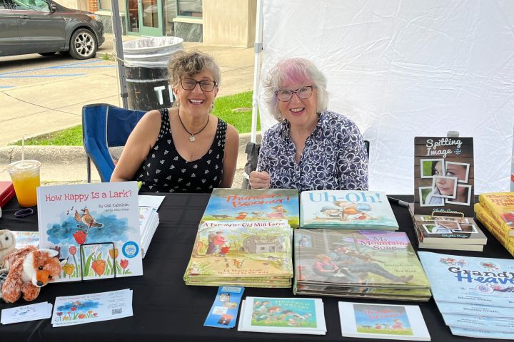 Two women at a table with their picture books